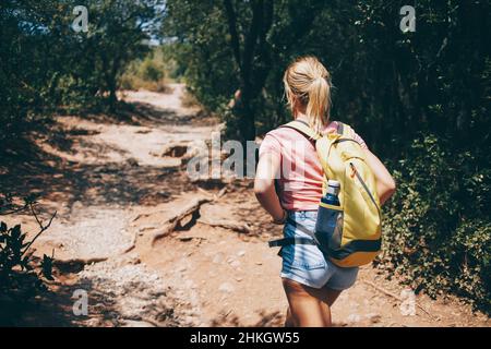 Reisende Dame, die im Wald auf dem Weg geht Stockfoto