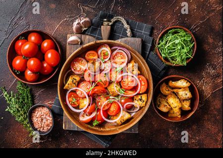 Toskanischer Panzanella-Salat, vegetarischer klassischer Salat mit Tomaten, Zwiebeln und Croutons. Dunkler Hintergrund. Draufsicht Stockfoto