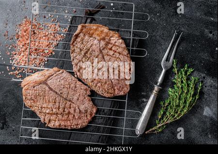 BBQ gegrilltes Rinderfleisch Sirloin Steaks auf dem Grill. Schwarzer Hintergrund. Draufsicht Stockfoto