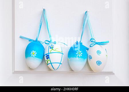 Ostereier hängen an einer weißen Tür. Stockfoto