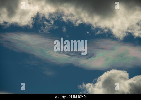 Verschiedene Farben in Wolke am blauen Himmel zwischen weißen Wolken Blaupinken und Grünsonnen Reflexion in Wolken am blauen Himmel atmosphärische Wirkung oben Stockfoto