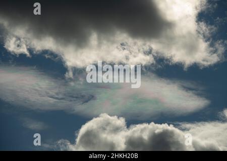 Verschiedene Farben in Wolke am blauen Himmel zwischen weißen Wolken Blaupinken und Grünsonnen Reflexion in Wolken am blauen Himmel atmosphärische Wirkung oben Stockfoto