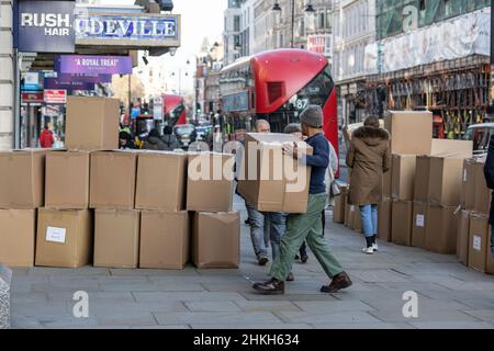 Pappkartons vor einem Bekleidungsgeschäft in der Hauptstraße, während Arbeiter und Käufer langsam in die Hauptstadt London, England und Großbritannien zurückkehren Stockfoto