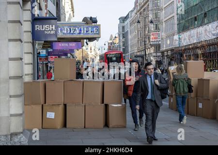 Pappkartons vor einem Bekleidungsgeschäft in der Hauptstraße, während Arbeiter und Käufer langsam in die Hauptstadt London, England und Großbritannien zurückkehren Stockfoto