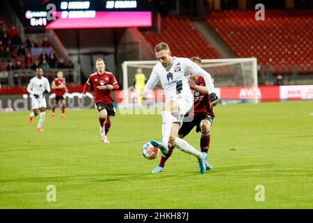 Nürnberg, Deutschland. 04th. Februar 2022. Fußball: 2nd Bundesliga, 1. FC Nürnberg - FC Ingolstadt 04, Matchday 21, Max-Morlock-Stadion. Ingolstadts Patrick Schmidt (Mitte) gewinnt ein Duell. Quelle: Daniel Löb/dpa - WICHTIGER HINWEIS: Gemäß den Anforderungen der DFL Deutsche Fußball Liga und des DFB Deutscher Fußball-Bund ist es untersagt, im Stadion und/oder vom Spiel aufgenommene Fotos in Form von Sequenzbildern und/oder videoähnlichen Fotoserien zu verwenden oder zu verwenden./dpa/Alamy Live News Stockfoto