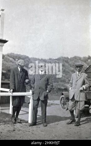 Um 1910, historisch, drei männliche Golfer in der stilvollen Golfkleidung der Zeit - zwei davon plus zwei - stehen draußen auf einem Links-Golfplatz, alle mit Stoffkappen. Der Mann in der Mitte, ist seine markante Jacke, ist J H Taylor, ein berühmter englischer Profi-Golfer dieser Zeit, von 1894 bis 1913 der Gewinner von fünf British Open Championships und einer der Pioniere des modernen Spiels. 1901 war er Mitbegründer der British Professional Golfer's Association. Stockfoto