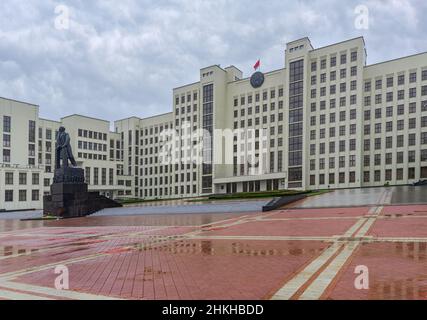 MINSK, WEISSRUSSLAND - 08 2019. November, Sowjetisches Denkmal die Statue Lenins mit dem großen Gebäude im Hintergrund in der Stadt Minsk, Weißrussland Stockfoto