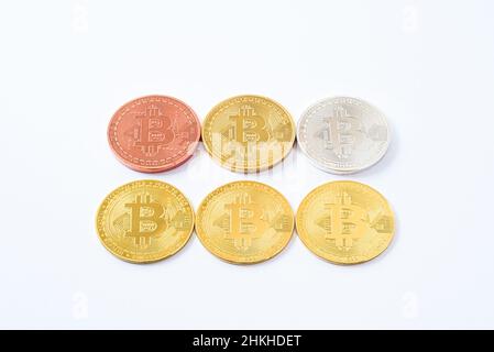 Sechs Bitcoin-Metallmünzen Reihen sich isoliert auf weißem Hintergrund an. Bitmünze aus Gold, Silber, Bronze, Kupfer. Stockfoto