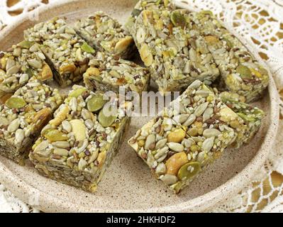 Dessert mit Honig, Flachs, Kürbiskernen und Nüssen. Kozinaki aus Kürbis- und Sonnenblumenkernen. Süßigkeiten aus Nüssen und Samen. Orientalische Süßigkeiten aus nächster Nähe Stockfoto