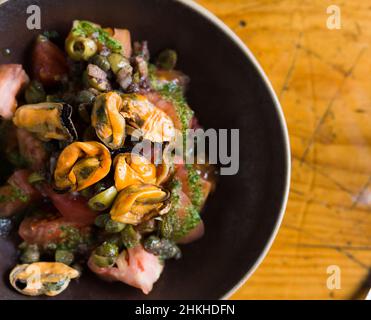 Mediterrane Küche - Muscheln und Tomaten mit Rucola-Pesto Stockfoto