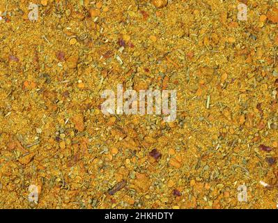 Würze für Fleisch aus gemahlenem Paprika, Pfeffer und getrockneten Kräutern. Würzende braune Ansicht von oben. Hintergrund von zerkleinerten Gewürzen. Stockfoto