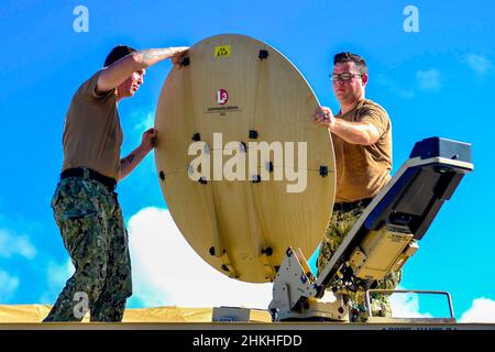 Santa Rita, Guam. 26th Januar 2022. Elektroniker 3rd Klasse Seth Helton, links, zugewiesen an Kommandant, Task Force 75 und Informationssystemtechniker 1st Klasse Johnathon McElroy hat während der Command Post Exercise (CPX) einen Hawkeye III Satelliten eingerichtet. CPX bietet den Mitarbeitern der Zentrale die Möglichkeit, die Rollen und Verantwortlichkeiten des Expeditionary Maritime Operation Center (EXMOC) in der humanitären Hilfe und Katastrophenhilfe einzuüben. Quelle: U.S. Navy/ZUMA Press Wire Service/ZUMAPRESS.com/Alamy Live News Stockfoto