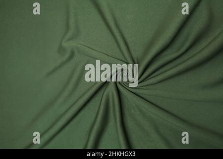Grün zerknittert oder gewellt Stoff Textur Hintergrund. Abstraktes Leinentuch mit sanften Wellen. Falten aus Satin, Seide und Baumwolle. Glatte, elegante Seide oder Atlas Stockfoto