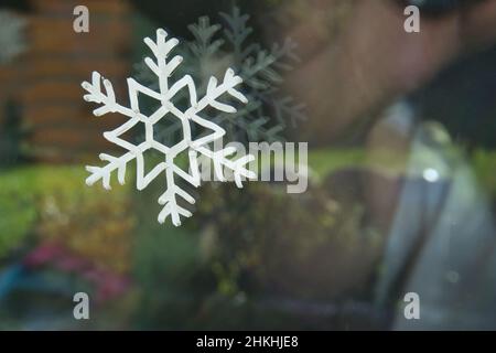 Schöne Aufnahme einer bemalten Schneeflocke auf dem Fenster. Stockfoto