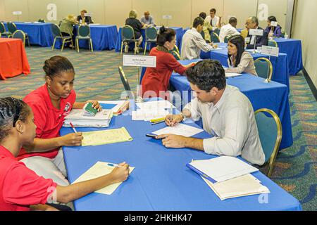 Miami Florida, Free Financial Planning Clinic, Certified Planner Hispanic Black Mann Frauen Mädchen Mädchen, Teenager Jugendliche Interview Notizen zu machen Stockfoto