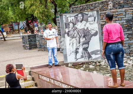 Soweto Johannesburg Südafrika, African Orlando West, Hector Pieterson Memorial, historische Apartheid Sam Nzima, schwarze Frau Mann posiert iPad fotografieren Stockfoto