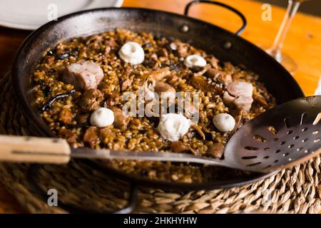 Köstlicher katalanischer Bergreis mit Pilzen und Schweinefüßen Stockfoto