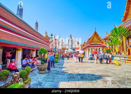 BANGKOK, THAILAND - 12. MAI 2019: Ruhende Touristen im Schatten eines großen Pavillons im Großen Palast, am 12. Mai in Bangkok, Thailand Stockfoto