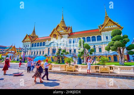 BANGKOK, THAILAND - 12. MAI 2019: Touristen, die am 12. Mai in Bangkok, Thaila, die prächtige Architektur des Throne Hall-Gebäudes des Großen Palastes genießen Stockfoto