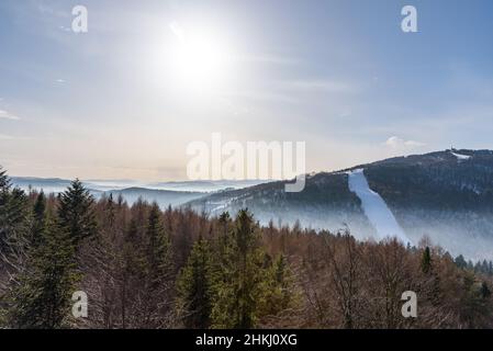 Neblige Ansicht des Beskid Sadecki Gebirges mit Skipiste von Jaworzyna Krynicka in Polen Stockfoto