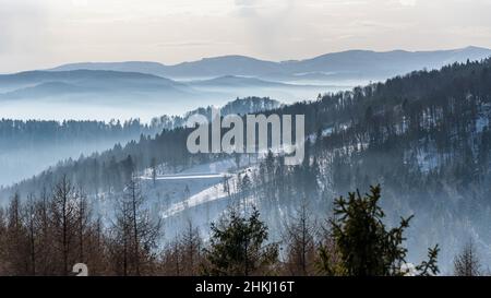 Neblige Ansicht des Beskid Sadecki Gebirges mit Skipiste von Jaworzyna Krynicka in Polen Stockfoto