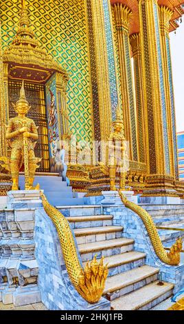 BANGKOK, THAILAND - 12. MAI 2019: Der Seiteneingang von Prasat Phra Thep Bidon wird mit vergoldeten Skulpturen von Yakshas und fünfköpfigen gekrönten Phaya bewacht Stockfoto