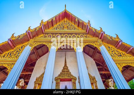 BANGKOK, THAILAND - 12. MAI 2019: Der goldene geschnitzte Giebel und das Dach des Ho Phra Monthiantham Tempels im Großen Palast, am 12. Mai in Bangkok, Th Stockfoto