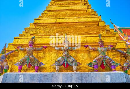 BANGKOK, THAILAND - 12. MAI 2019: Die farbenfrohen Skulpturen der Riesen (Yakshs) um die Basis der Phra Suvarnachedi Pagode des Tempels des Smaragd Budd Stockfoto