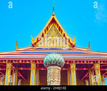BANGKOK, THAILAND - 12. MAI 2019: Der goldene Giebel des Ucosot-Tempels mit geschnitzten floralen Dekorationselementen und der Figur des gottes Narayana auf der Rückseite Stockfoto