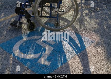 Rollstuhl auf Behindertenparkplatz reservierter Parkplatz, Behindertengerechter Respekt Stockfoto