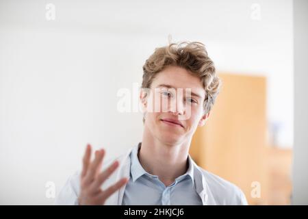 Junger Arzt männlich mit Mantel in einer Arztpraxis Stockfoto