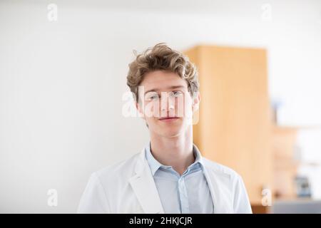 Junger Arzt männlich mit Mantel in einer Arztpraxis Stockfoto
