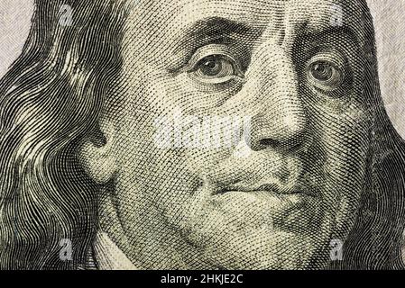 Nahaufnahme des Gesichts von Benjamin Franklin auf der 100-Dollar-Banknote. Banknote in nicht perfektem Zustand. Es gibt einige Schäden daran. Stockfoto