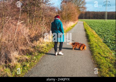 Frau im Alter von 30-35 Jahren, die mit ihrem Hund unterwegs ist Stockfoto