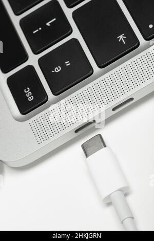 Nahaufnahme des usb-C-Kabels, das an einen Laptop angeschlossen ist. Stockfoto