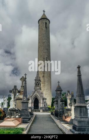 Dublin, Irland, August 2019 Round Tower und antike Gräber und Grabsteine auf dem Friedhof von Glasnevin Stockfoto