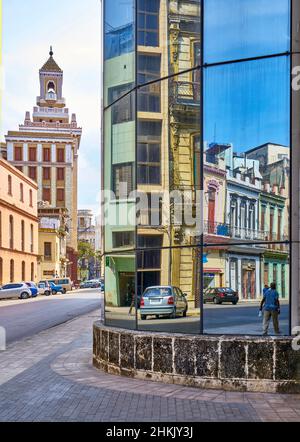 Verkleidungen von Häusern im Kolonialstil spiegeln sich in einer Glasfassade eines modernen Gebäudes, Kuba, La Habana, wider Stockfoto