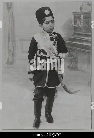 Kunst inspiriert von Portrait of Malijak Aziz al-Sultan oder Ahmad Shah as a Young Boy, einer von 274 Vintage-Fotografien, Gelatin Silber-Fotografie, ca. 1890 oder 1900-1905, Qajar, Qajar-Periode, 6 1/2 x 4 9/16 Zoll, 16,5 x 11,6 cm, schwarz-weiß, Junge, zeremoniell, formell, Iran, Medaillon, Militär, Klassische Werke, die von Artotop mit einem Schuss Moderne modernisiert wurden. Formen, Farbe und Wert, auffällige visuelle Wirkung auf Kunst. Emotionen durch Freiheit von Kunstwerken auf zeitgemäße Weise. Eine zeitlose Botschaft, die eine wild kreative neue Richtung verfolgt. Künstler, die sich dem digitalen Medium zuwenden und die Artotop NFT erschaffen Stockfoto