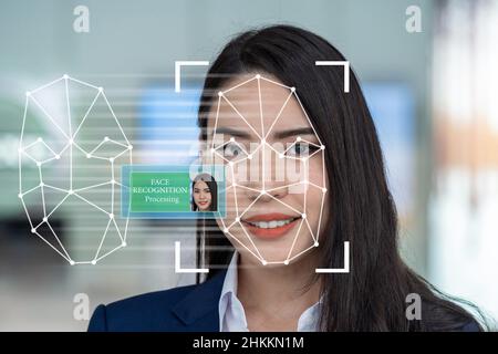 Asiatische Frauen nutzen Gesichtserkennungs- und Erkennungstechnologie für Zugangsberechtigungen, künstliche Intelligenz und Augmented Reality mit Technologie-Conce Stockfoto