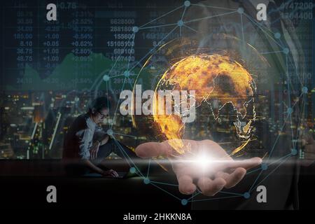 Doppelte Exposition der Geschäftsmann Hand hält die Partikel Erde mit Technologie-Netzwerk Kreis über asiatische Geschäftsmann mit Laptop zeigt die Aktien ma Stockfoto