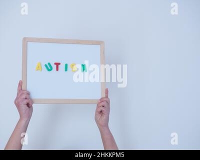 Wort Autismus mit farbigen magnetischen Buchstaben auf weißem Brett. Gesundheitskonzept. Stockfoto