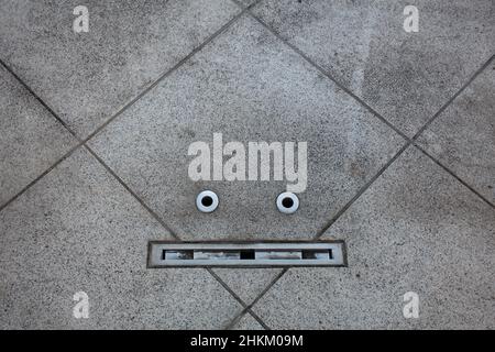 Details auf einem Boden ähneln einem Gesicht in einem Beispiel von Pareidolie. Tokio, Japan. Stockfoto