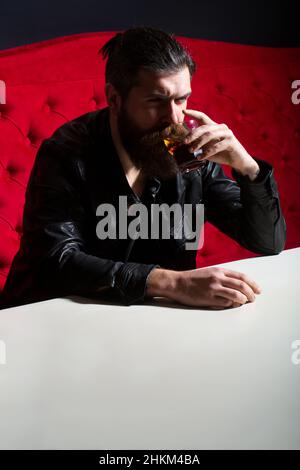 Betrunkener Kerl mit Problem von Alkoholabhängigkeit Missbrauch, Alkoholismus Konzept. Bärtiger Hipster trinkt Whisky, Whiskey oder Cognac-Brandy. Stockfoto
