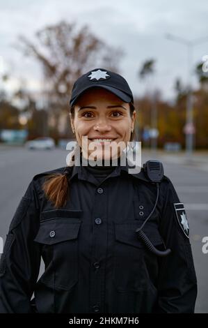 Porträt einer lächelnden Polizistin auf der Straße Stockfoto