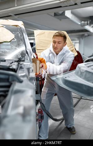 Reparaturman hält Drehpolierer für die Kitt-Korrektur Stockfoto