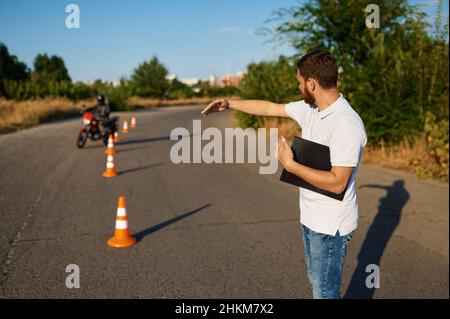Schüler fährt um die Kegel, Motorradschule Stockfoto