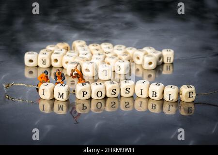 Miniatur-Modell der Menschen entfernen Holzwürfel mit Wort unmöglich, möglich. Persönliche Entwicklung und Karriereentwicklung oder ändern Sie sich selbst Konzept. Stockfoto