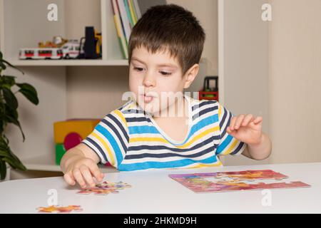 Ein Vorschulkinder spielt Puzzles, stellt ein Bild zusammen Stockfoto