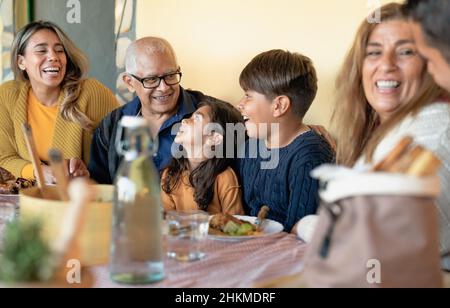 Fröhliche lateinamerikanische Familie, die zu Hause Spaß beim gemeinsamen Mittagessen hat Stockfoto