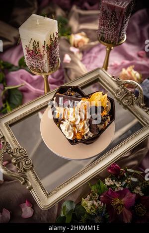 Stillleben des Eisbecher in herzförmiger Schokoladenschale zum Valentinstag Stockfoto